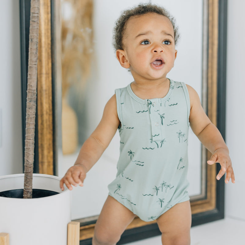 Palm green bamboo tank romper in size 12-18M on baby standing in a studio.